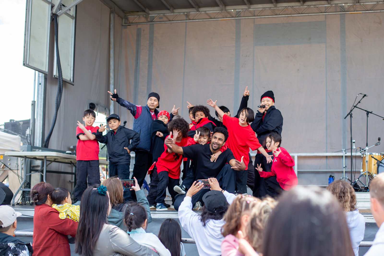 A dance group performing for a packed outdoor audience