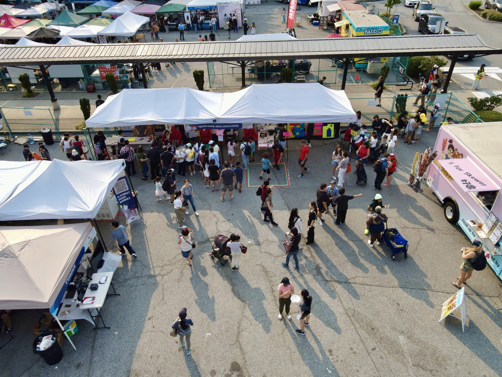 Festival visitors gathering around activity booths viewed from above